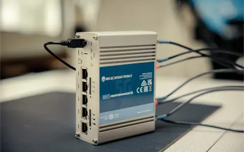 En silverfärgad 5G-router med flera LAN-portar och antennkablar. Perfekt för mobilt bredband i Europa.
