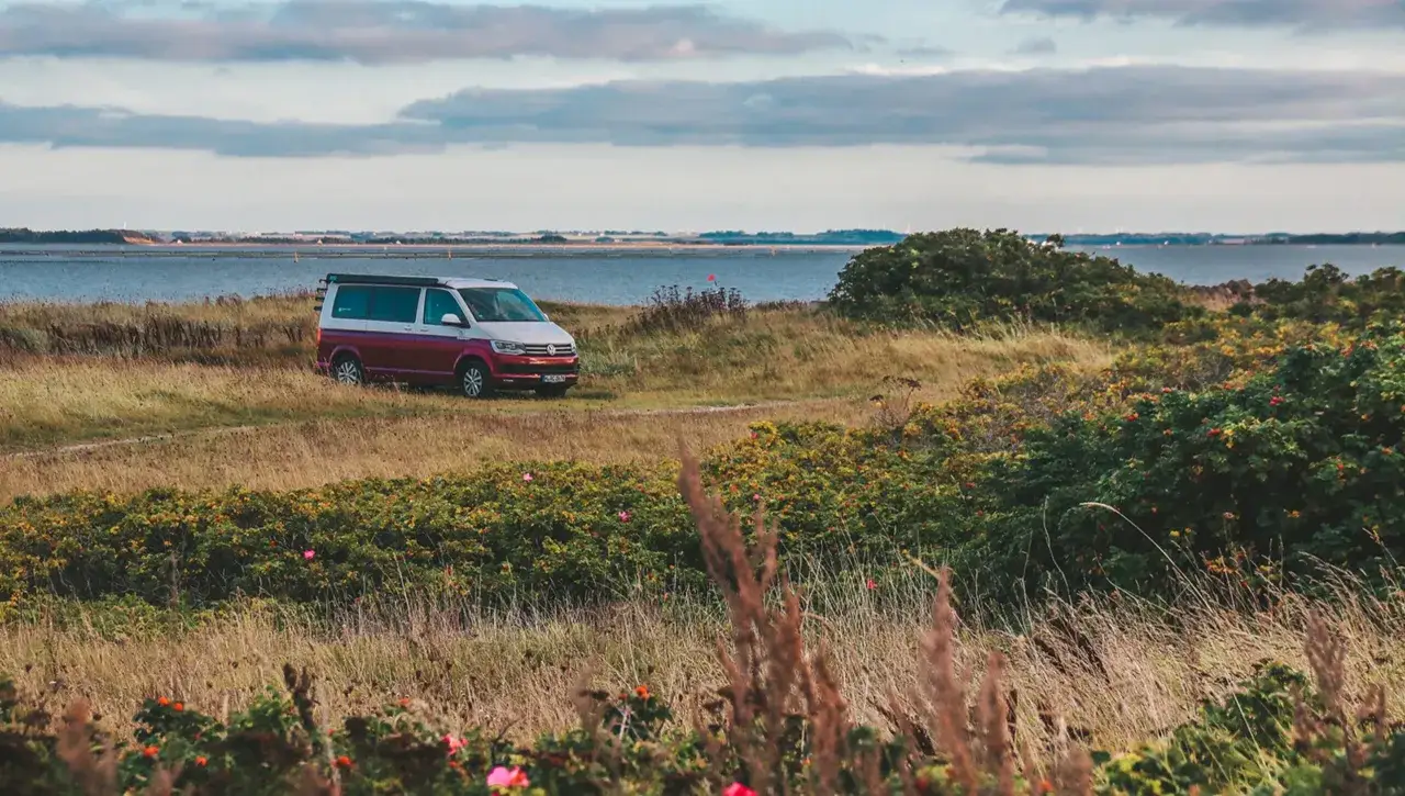 Husbil parkerad vid en kustv&auml;g i Danmark, redo f&ouml;r ett &auml;ventyr.