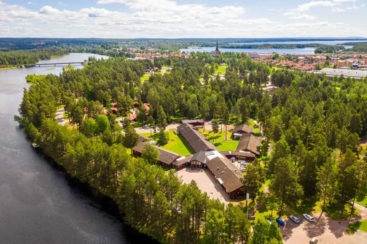 Vacker vy &ouml;ver Moraparken Camping med sj&ouml;, skog och stad i bakgrunden.