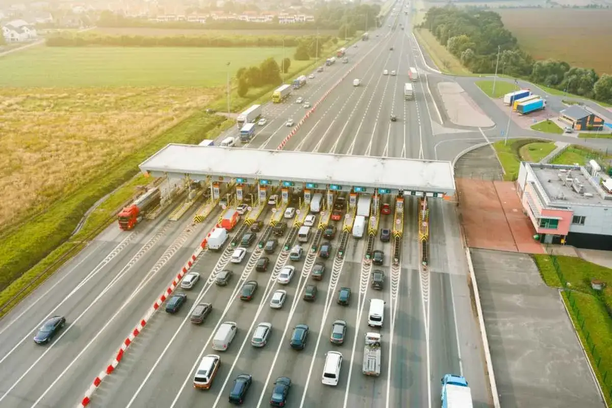 Trafik vid en bompeng i Norge. Bilar och lastbilar köar för att passera betalstationen.