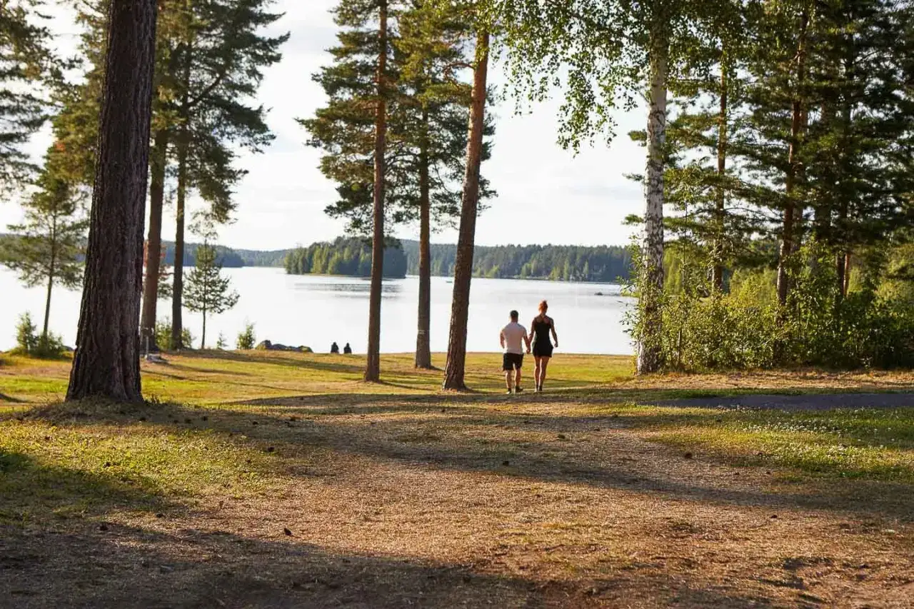 Ett par promenerar hand i hand vid en sj&ouml;, en idyllisk plats f&ouml;r f&ouml;rsta camp ansia.